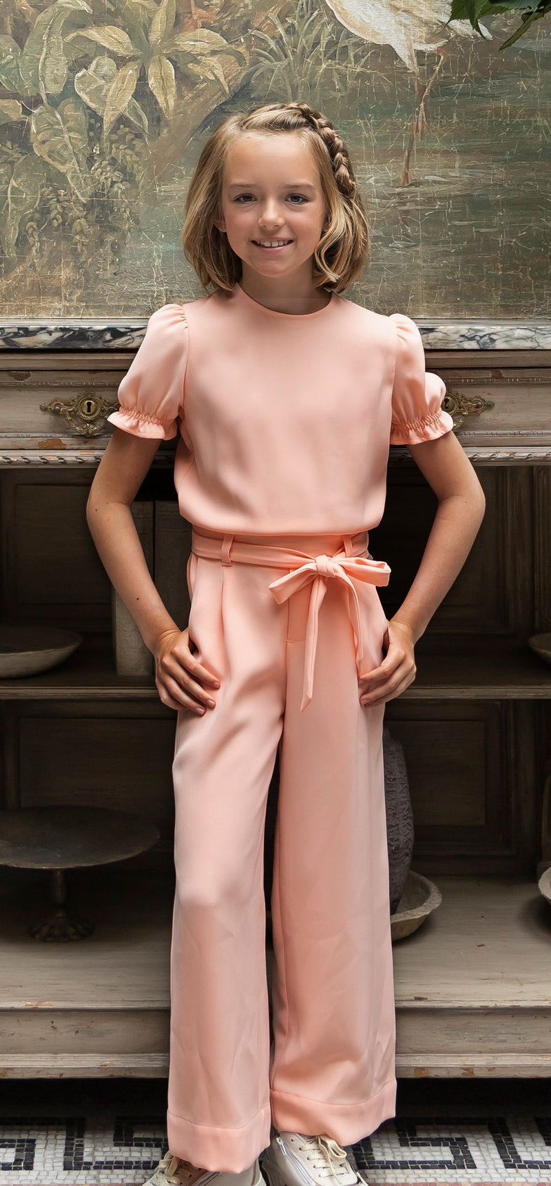 Zalmroze jumpsuit gecombineerd met een jeansjasje