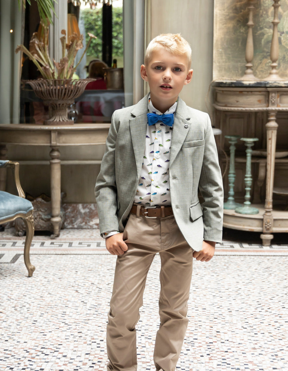 Beige chinobroek, kaki jasje en speels hemd met blauwe strik