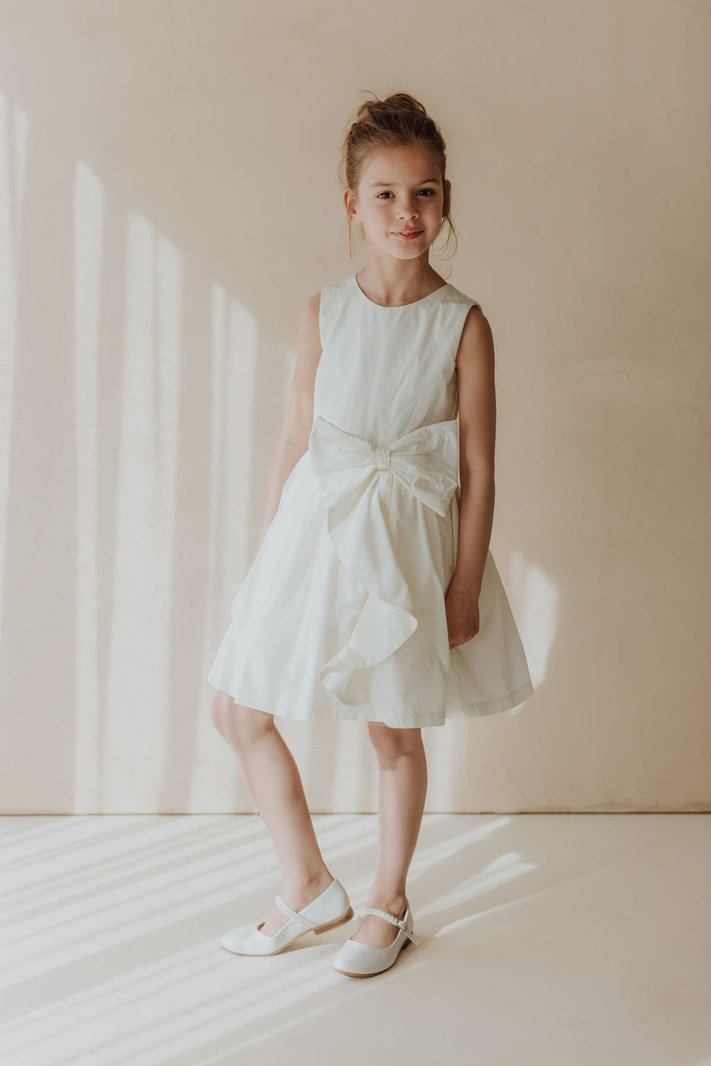 Robe élégante, blanc nacré, avec de beaux appliqués floraux à la taille et cardigan assorti