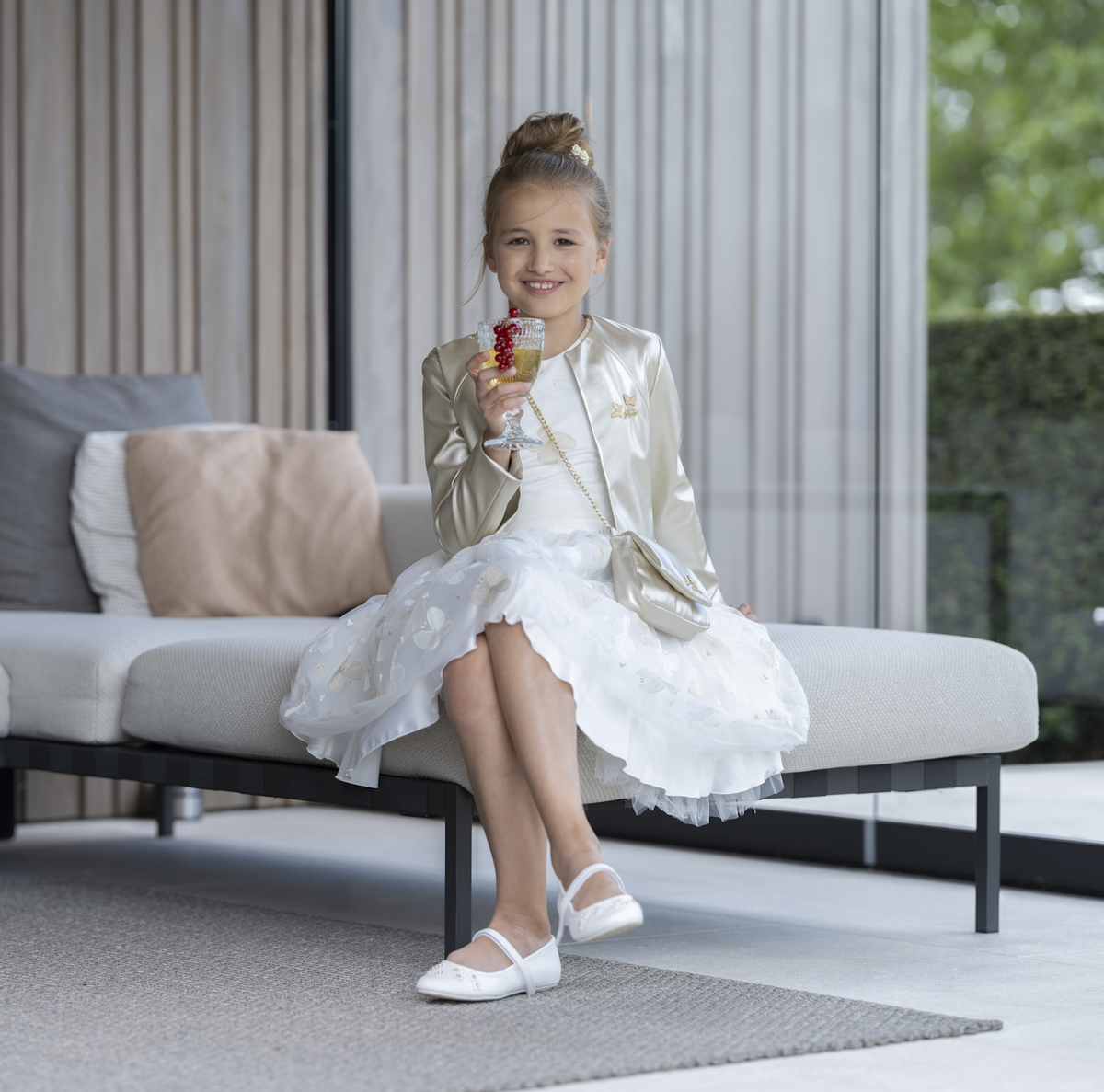 Parelwitte tullejurk met goudkleurige vlinders gecombineerd met jacket in lederlook
